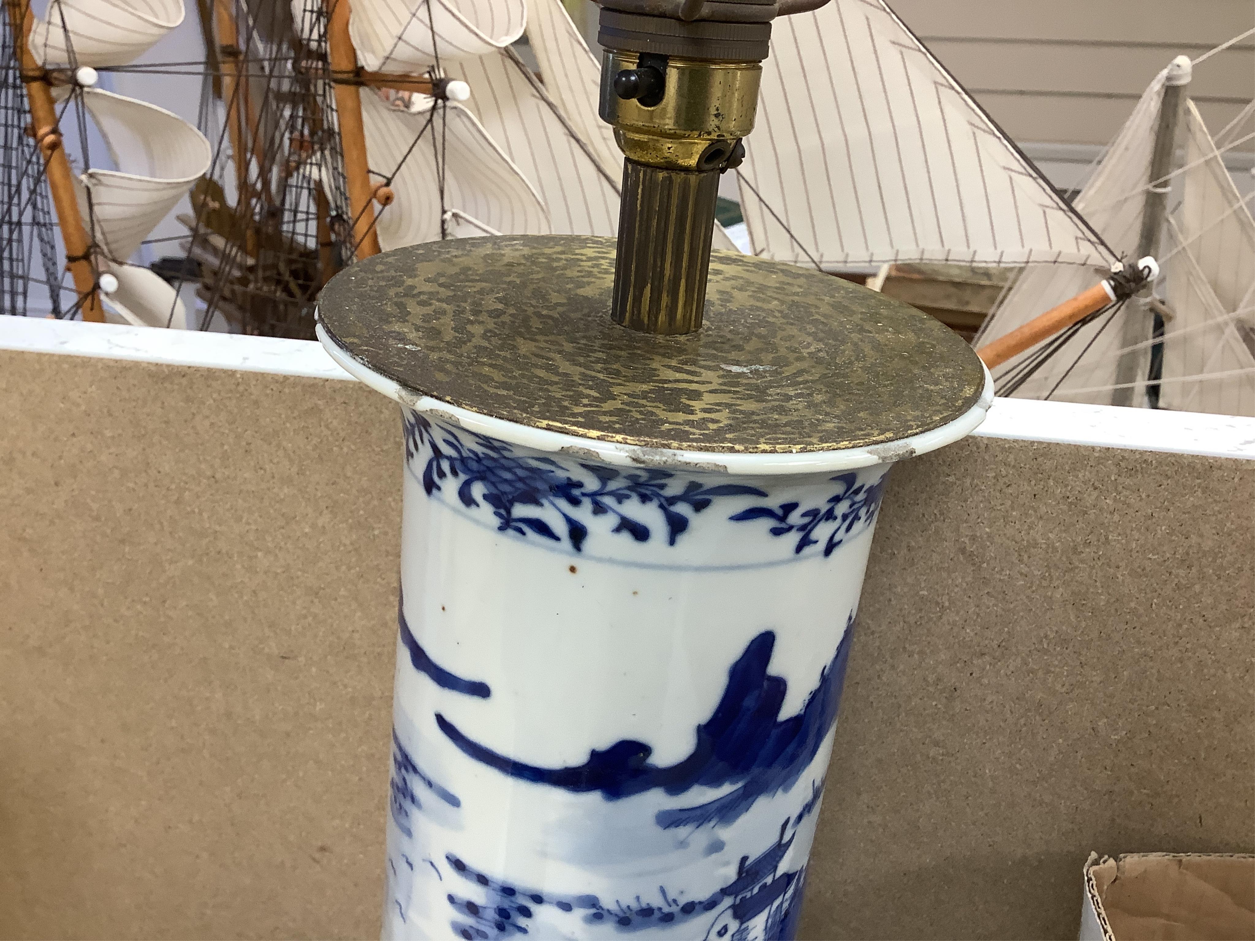 A pair of tall Chinese blue and white ‘landscape’ sleeve vases, c.1900, drilled and mounted as lamps with shades, 39cm high excluding the fitting